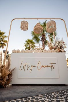 a sign that says let's go coconuts on it with palm trees in the background