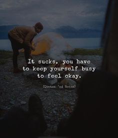 a man standing next to a campfire with a quote on it that reads, it sucks, you have to keep yourself busy to feel okay