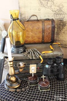 there are many items on the table including an old suitcase, binoculars and other things