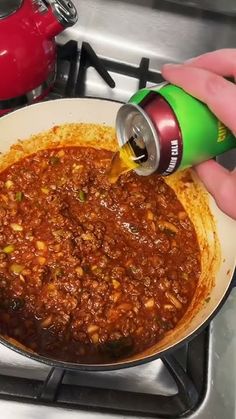 someone is pouring chili into a skillet on the stove