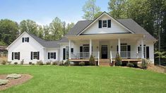 a large white house sitting on top of a lush green field