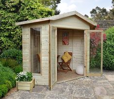 a small wooden shed sitting in the middle of a garden