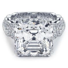 a large diamond ring with three rows of diamonds on the sides and an intricate band around it