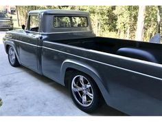 an old gray truck parked in a driveway