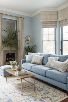 a living room with blue couches and pillows on the floor next to a fireplace