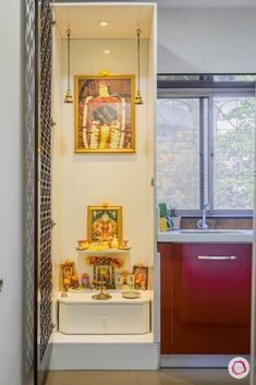 an open door leading to a kitchen with paintings on the wall and sink in it