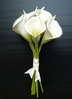 a bouquet of white flowers on a black background with the stems still attached to it