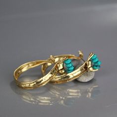 This unique and powerful design of golden crown hoop earrings came out of a session in my studio when the flattened gold filled material had been accidentally folded on both sides. The gold filled was flattened and created a rustic, ancient look that would've blended beautifully when the Aztecs were once in power.Turquoise howlite golden crown hoop earrings would be a perfect compliment for a wedding party or as a wedding gift.The earring's backs are handmade and have a very useful and comfortab Turquoise Metal Hoop Earrings, Turquoise Hoop Gemstone Jewelry, Turquoise Hoop Earrings With Natural Stones, Turquoise Gemstone Hoop Jewelry, Elegant Turquoise Hoop Earrings, Turquoise Metal Round Hoop Earrings, Turquoise Brass Hoop Earrings As Gift, Turquoise Brass Hoop Earrings For Gift, Turquoise Hoop Metal Jewelry