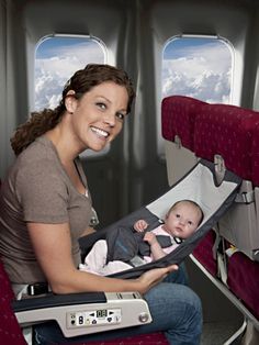 a woman holding a baby in an airplane seat