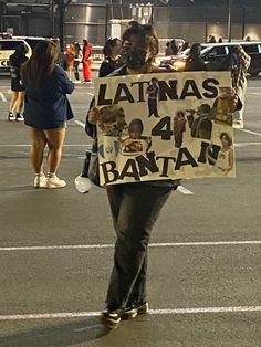 a woman holding a sign that says latinas 4 / 4 y bantams