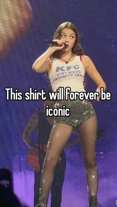 a woman in short shorts on stage with the words this shirt will forever be iconic