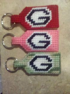 three keychains with the letter g on them