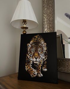 a painting of a leopard on a table next to a lamp