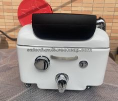 an old fashioned white toaster sitting on top of a table