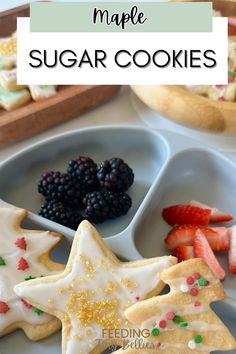 homemade sugar cookies with berries and strawberries in the middle on a white plate next to other small trays