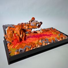 a lego model of two people sitting on top of an orange and red structure with blocks