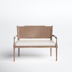 a bench made out of wicker with a cushion on the back and armrests