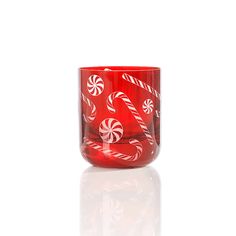 a red glass cup with candy canes on the inside is shown against a white background