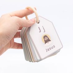 a hand holding a stack of cards with the word jesus on it and a monkey sticker