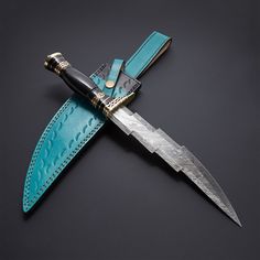 a knife that is sitting on top of a blue leather case with a black handle