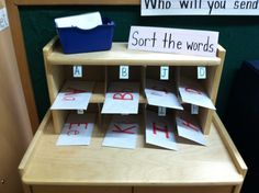 a wooden desk topped with lots of cut out letters and paper on top of it