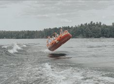 a group of people riding on the back of a boat in the middle of water