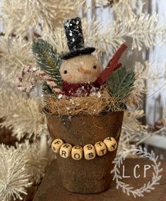 a snowman sitting in a pot on top of a table