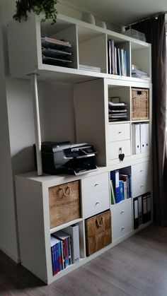 a white bookcase filled with lots of books next to a window and a wooden floor