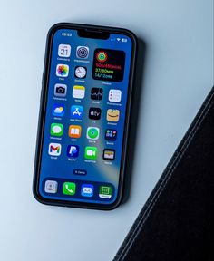 an iphone sitting on top of a table next to a black case with icons on it