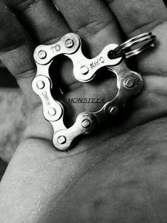 a person holding a bike chain in the palm of their hand and wearing a pair of scissors