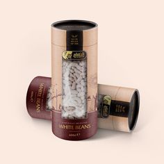 an open canister filled with white beans next to two empty tins on a pink background