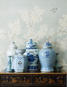 blue and white vases are sitting on a dresser