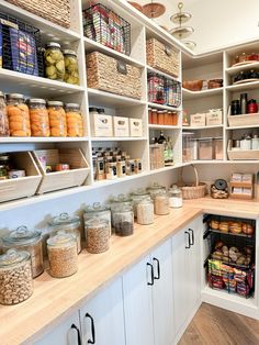 an organized pantry with lots of food in jars and baskets on the shelves, along with other items