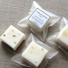 three pieces of soap sitting next to each other on top of a cloth covered table