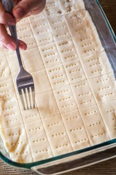 a person is using a fork to make crackers