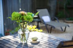 flowers in a vase sitting on a table outside