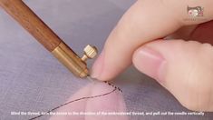 a person is stitching something with a needle