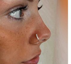 a close up of a woman's face with piercing on her nose