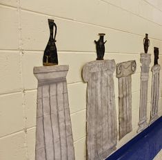 five vases are lined up on the wall