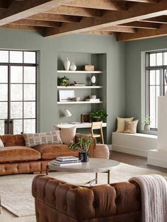 a living room filled with lots of furniture next to two windows and a coffee table