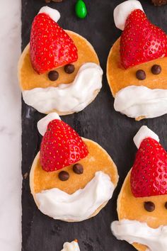 some cookies with strawberries and chocolate chips on them are decorated like santa claus's hat