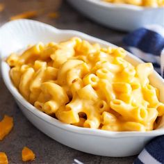 a white bowl filled with macaroni and cheese on top of a blue towel