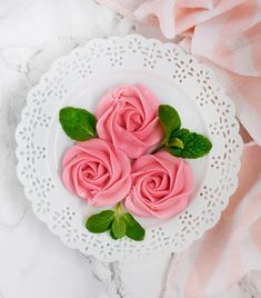 three pink roses are on a white plate