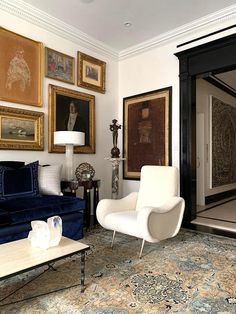 a living room filled with furniture and pictures on the wall above it's doorway