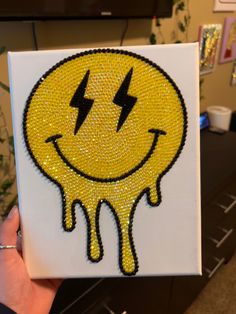 a yellow smiley face with two lightning bolts on it's side and dripping paint