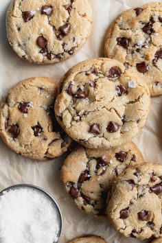 chocolate chip cookies on parchment paper next to a glass of milk