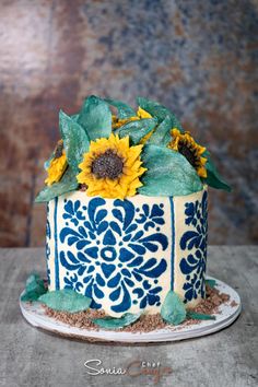 a blue and white cake with sunflowers on top