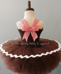 This adorable gingerbread tutu dress features brown glitter tulle and frosting! The straps are adjustable by tightening the bow in the back. Skirt length: 0-6 months is approximately 4 inches long. 6 mos - 2T is approximately 6 inches long. 3-4T is approximately 8 inches long. 5-6T is approximately 10 inches long.Skirt length: 3-9 months is approximately 4 inches long. 9-24 months is approximately 5 inches long. 3/4T is approximately 6 inches long. 5/6T is approximately 8 inches long. Sweet Ruffled Fitted Tutu Dress, Sweet Fitted Ruffle Tutu Dress, Cute Tulle Tutu Dress With Bow, Cute Fitted Christmas Tutu Dress, Cute Fitted Tutu Dress For Christmas, Cute Christmas Tutu Dress With Ruffles, Sweet Fitted Tutu Dress In Tulle, Sweet Fitted Tulle Tutu Dress, Brown Glitter