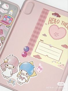 an open notebook with stickers on it and a hello kitty notepad next to it