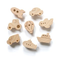 several wooden toys are arranged in the shape of boats and ships on a white background